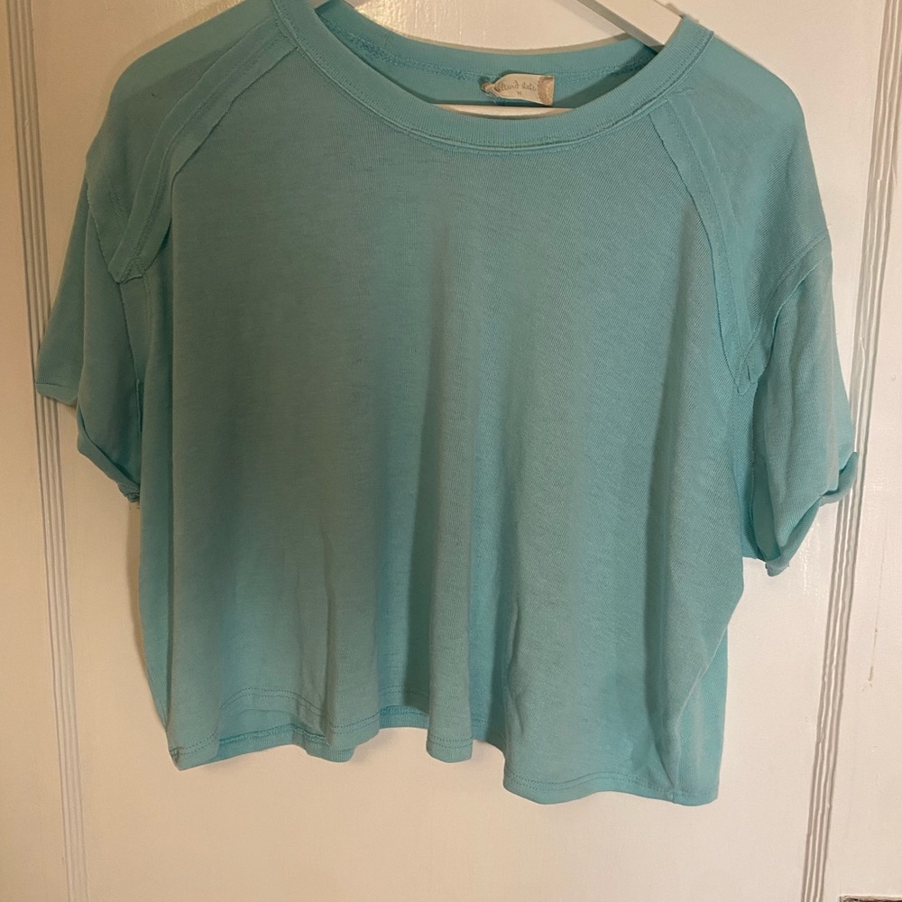 Soft blue-green colored cropped shirt.